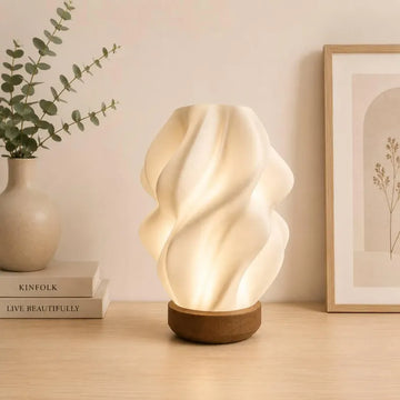 Luminária escultural em forma de onda, feita de plástico reciclado, com base de madeira, estilo boho moderno.